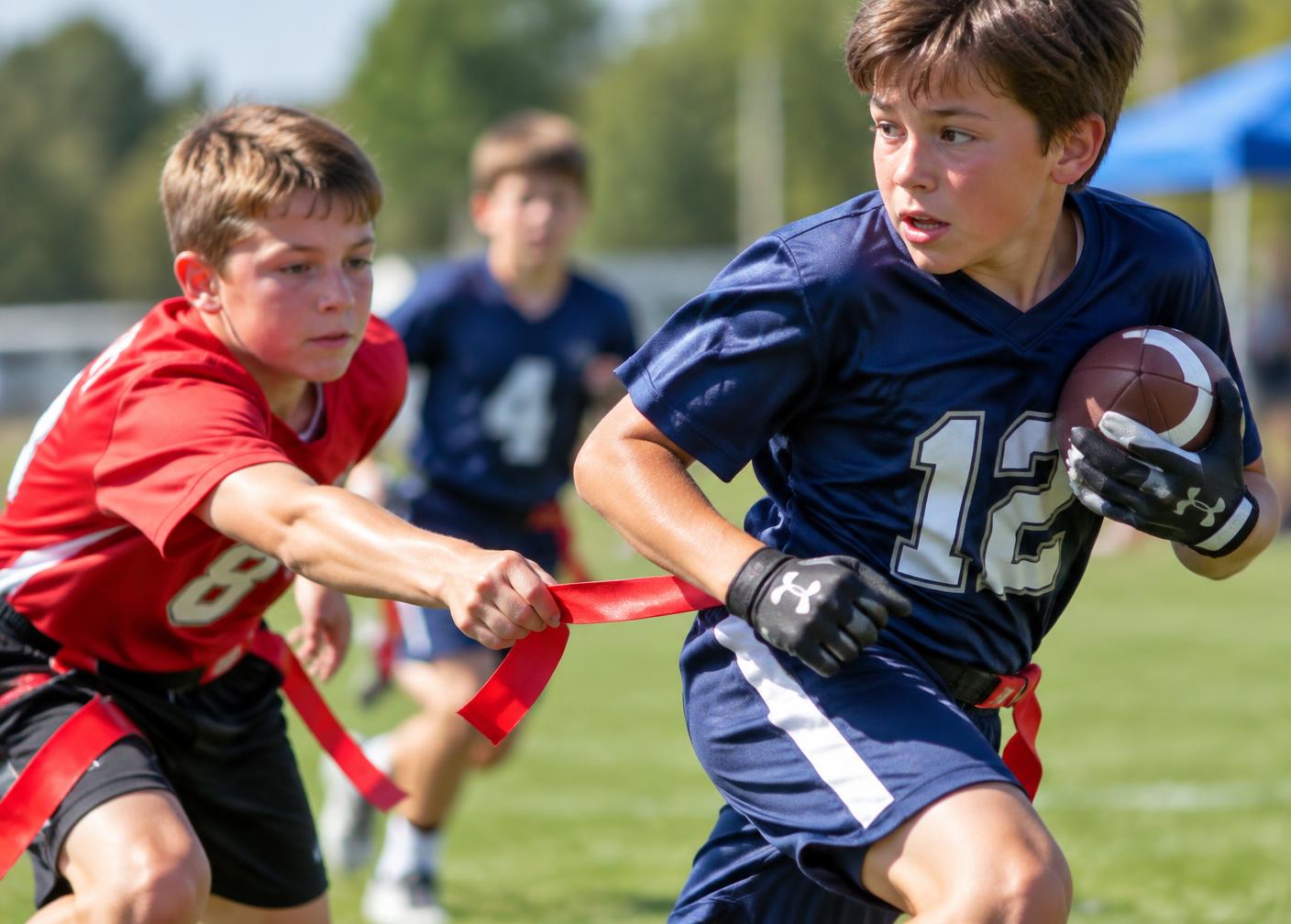 A defender pulling the red flag from the belt of a young player carrying the ball
